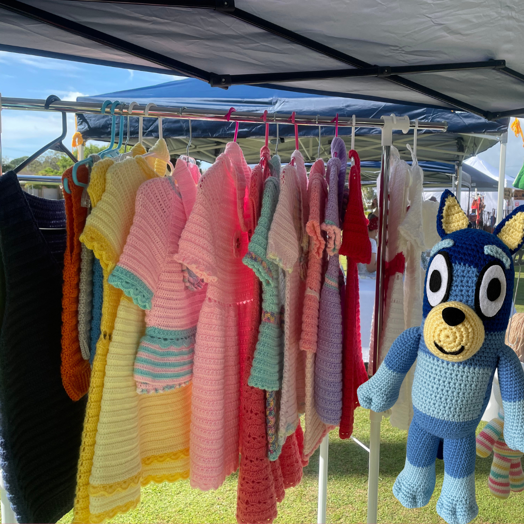 An image of handmade crocheted dresses and toys