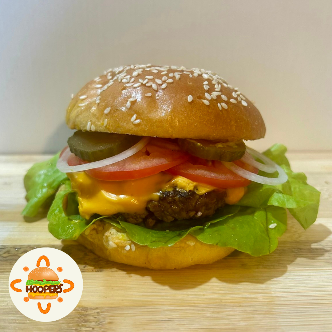 A burger with lettuce, cheese, tomato, onion, pickles and a beef patty